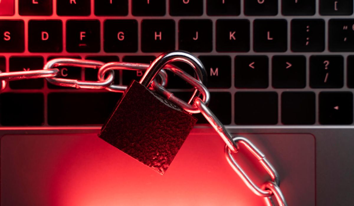 A padlock and chain resting on a laptop keyboard, symbolizing digital security and data protection.
