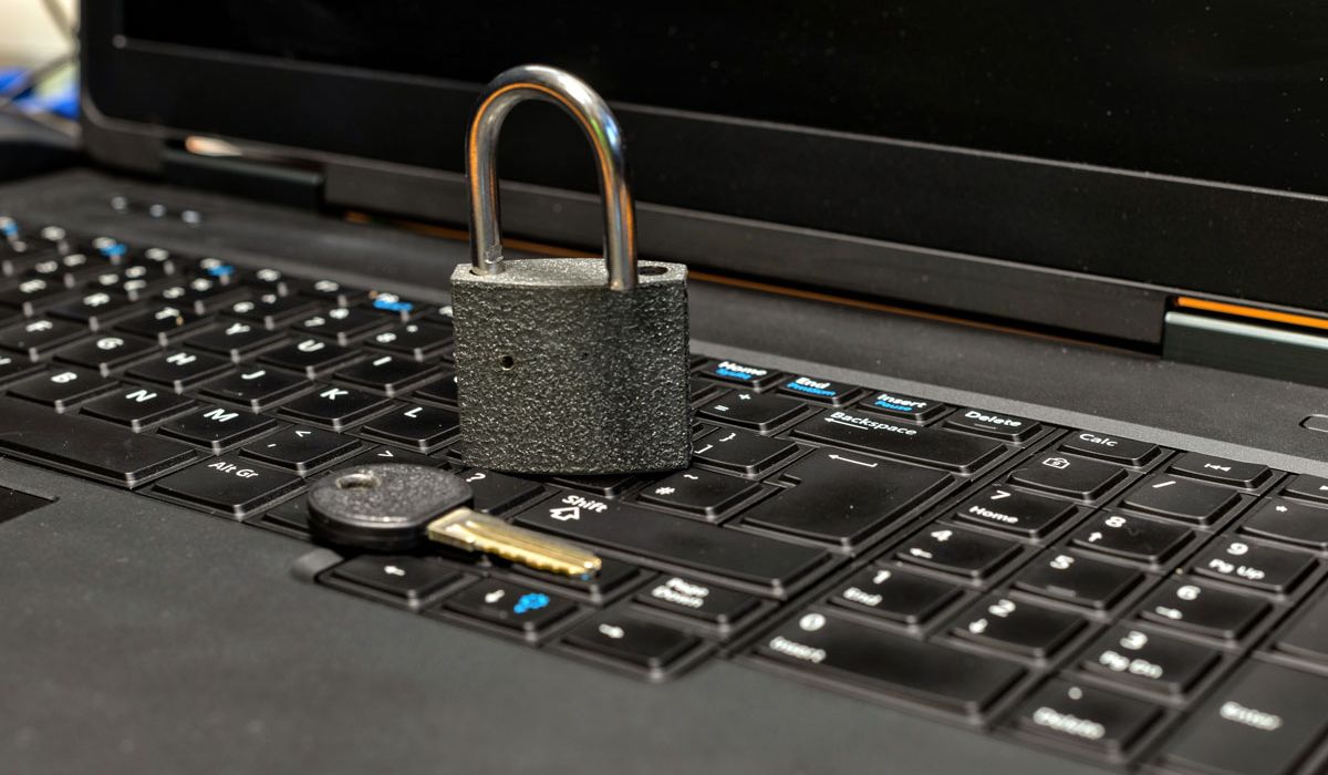 A padlock resting on a laptop keyboard, symbolizing digital security and data protection.