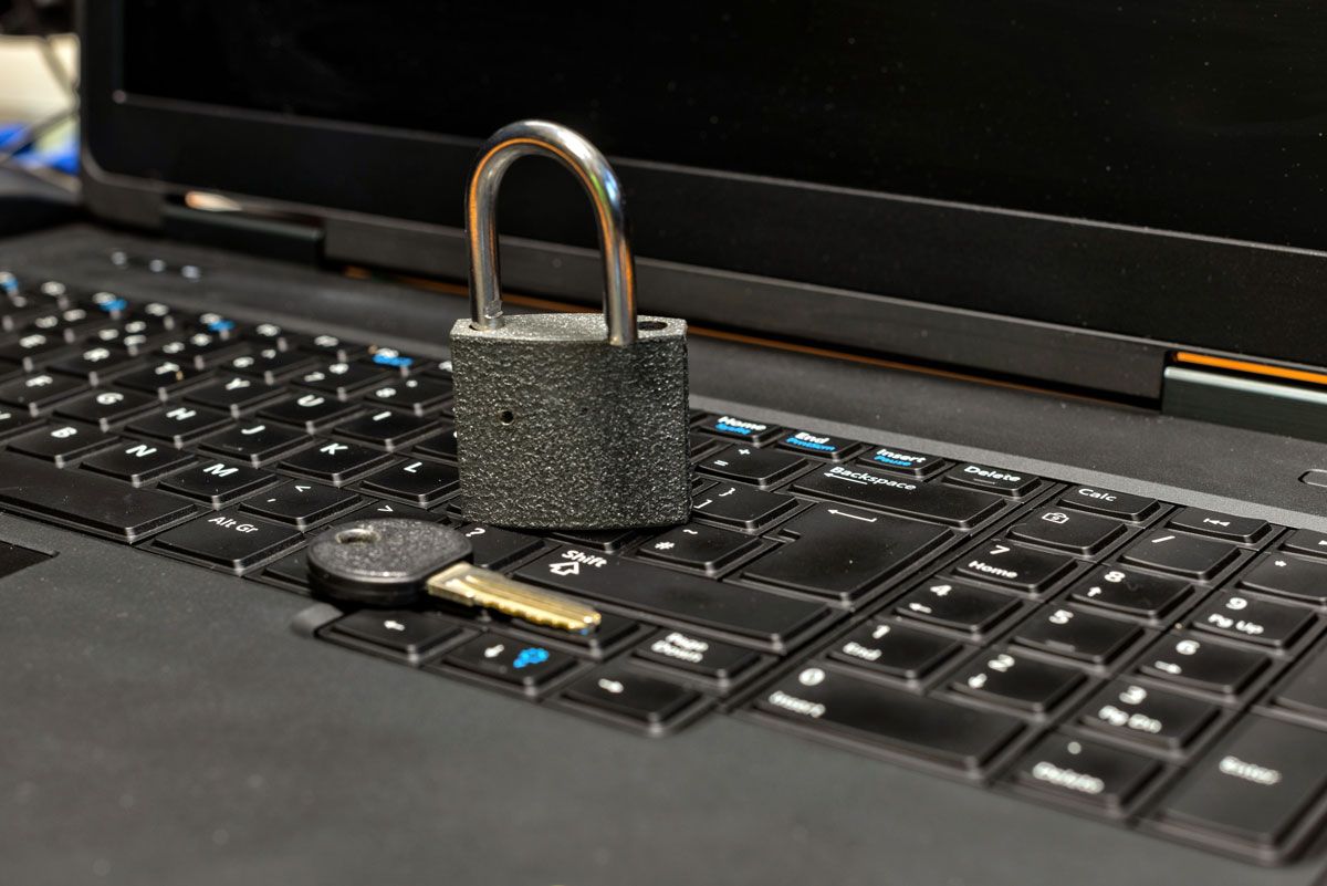 A padlock resting on a laptop keyboard, symbolizing digital security and data protection.